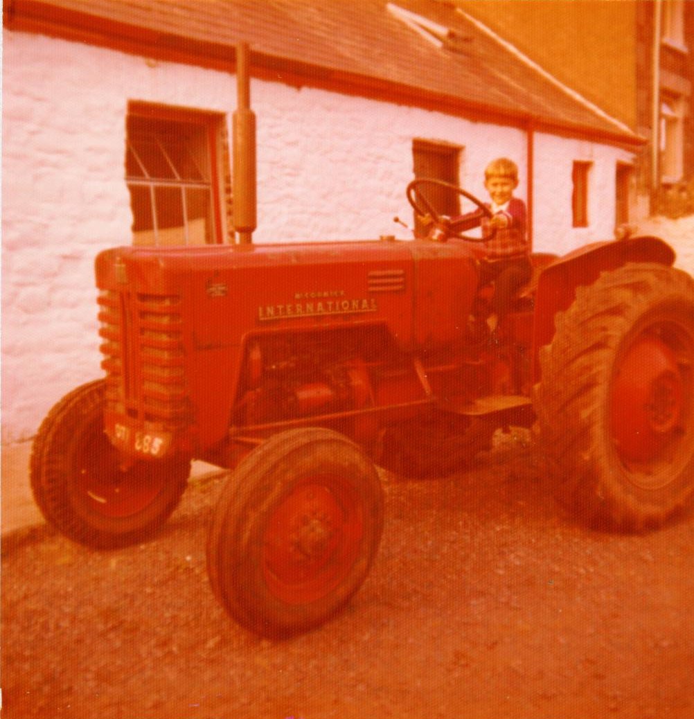Historic 1970s Henbont Holidays family photo featuring a boy on a tractor at the farm